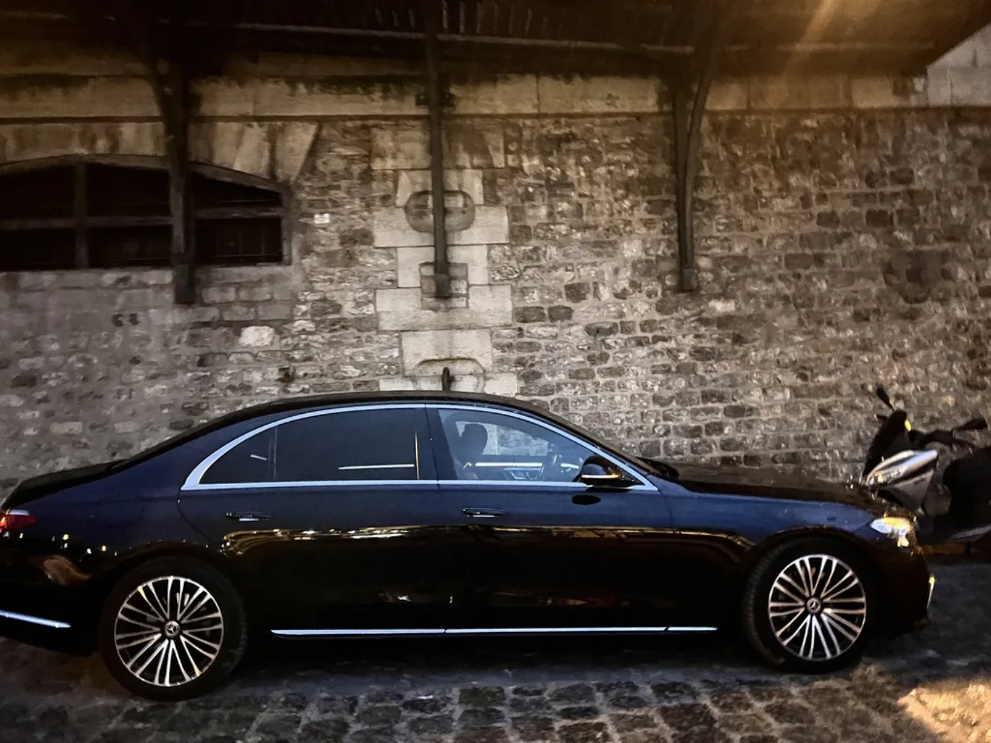Mercedes Classe S DRIVIGO sur une ruelle pavée de Paris en soirée